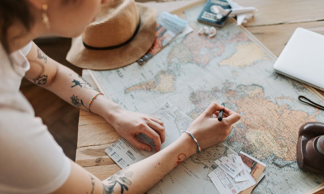 persona planificando un viaje con pasaporte y documentos sobre la mesa