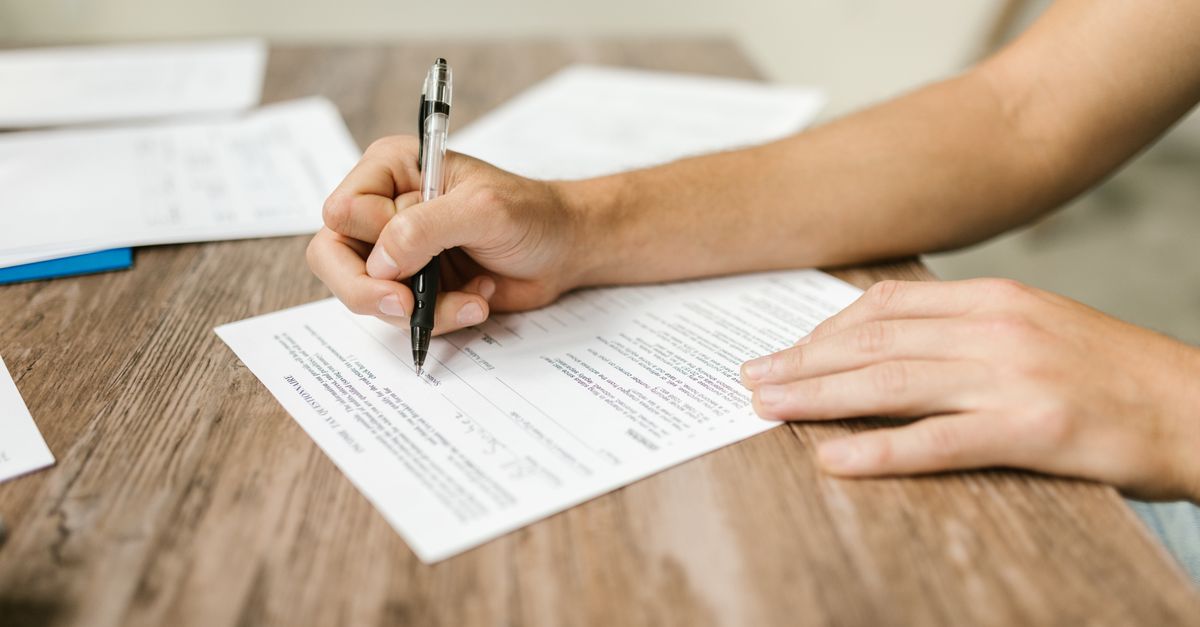 Persona llenando a mano la solicitud de renovación del permiso de trabajo (EAD).