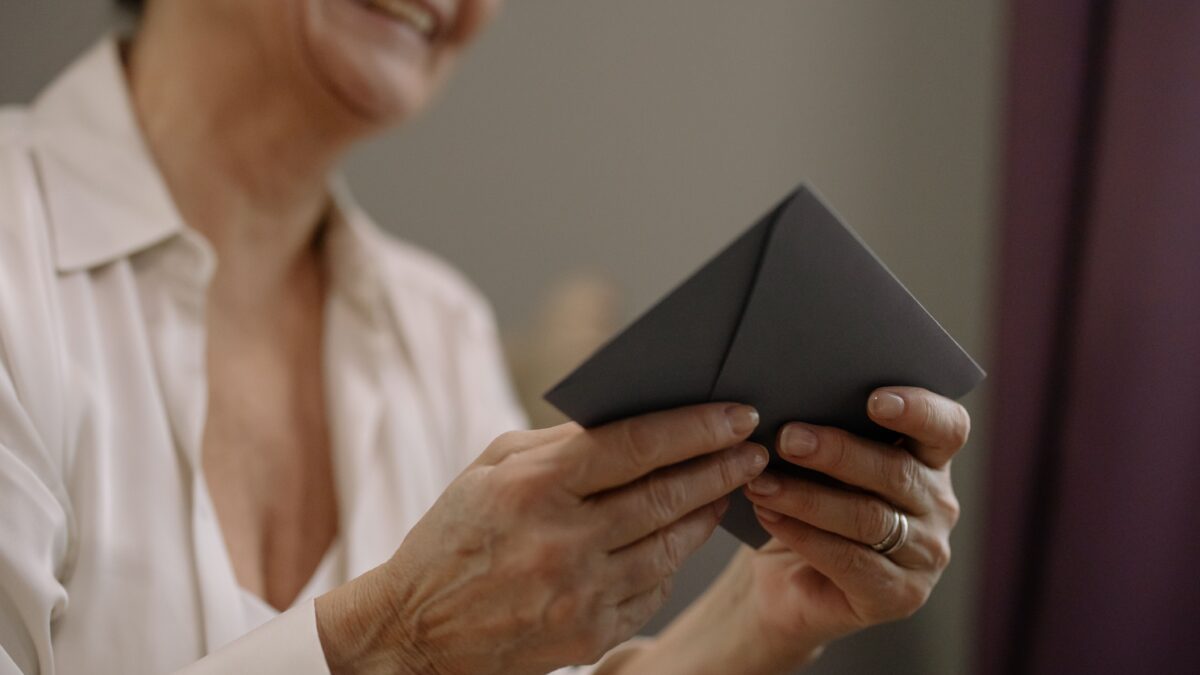 Smiling older woman holding a Social Security letter with the 2027 increase notice.