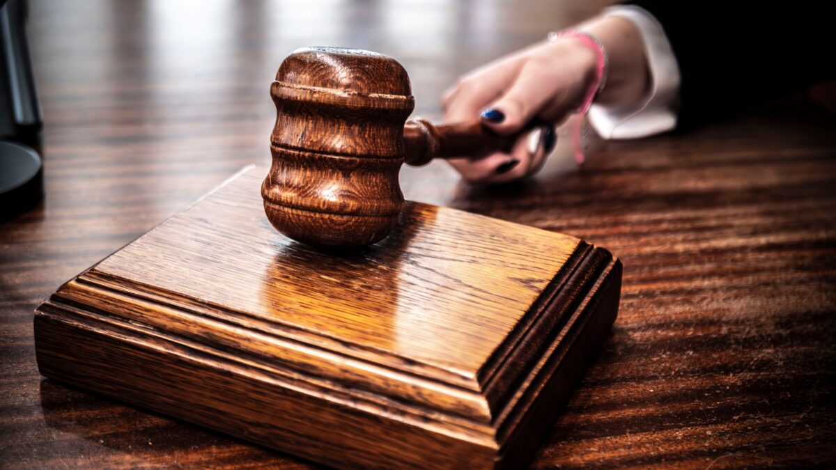 Wooden judge's gavel striking its sound block in a courtroom