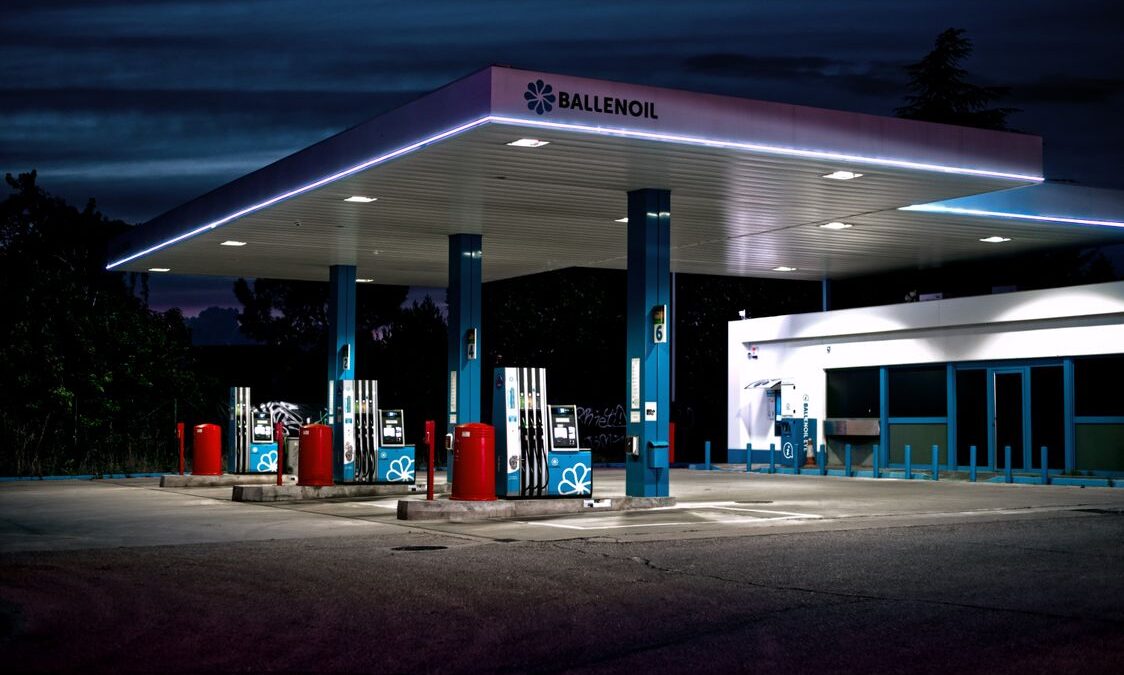 Gas station lit up at night with empty fuel pumps