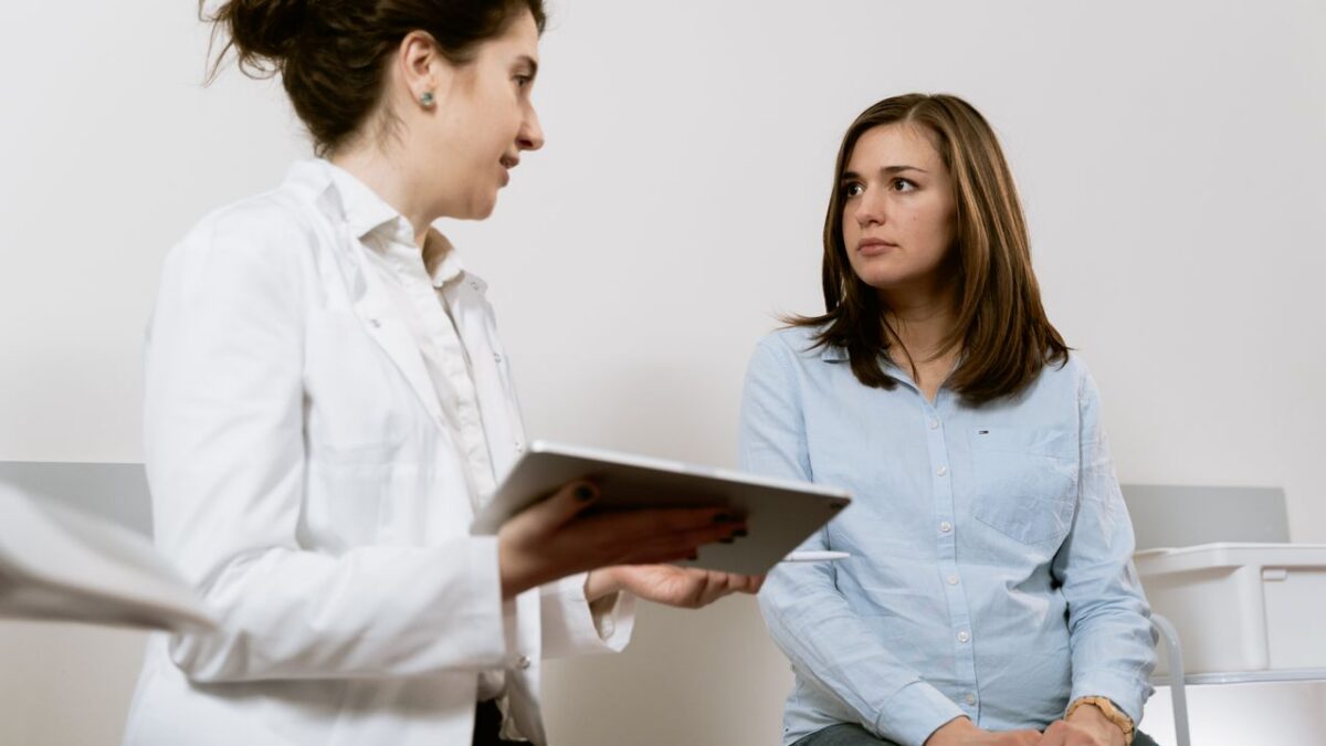 Doctor consulting a pregnant patient about healthcare options at a clinic