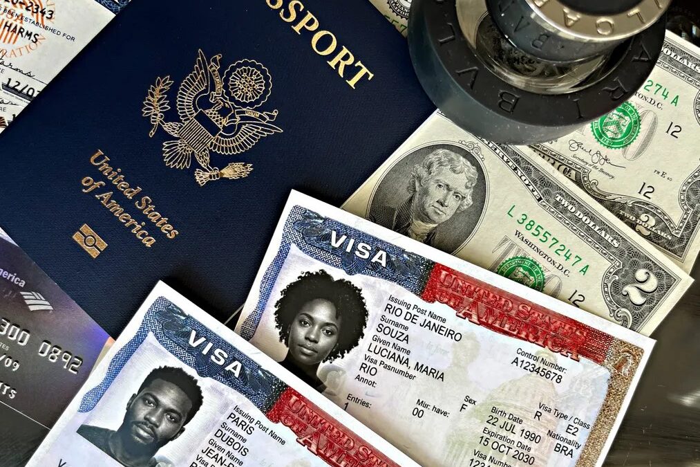 Pasaporte de Estados Unidos junto a visas americanas, billetes de dólar y un sello, tras el anuncio de más de 300,000 visas revocadas