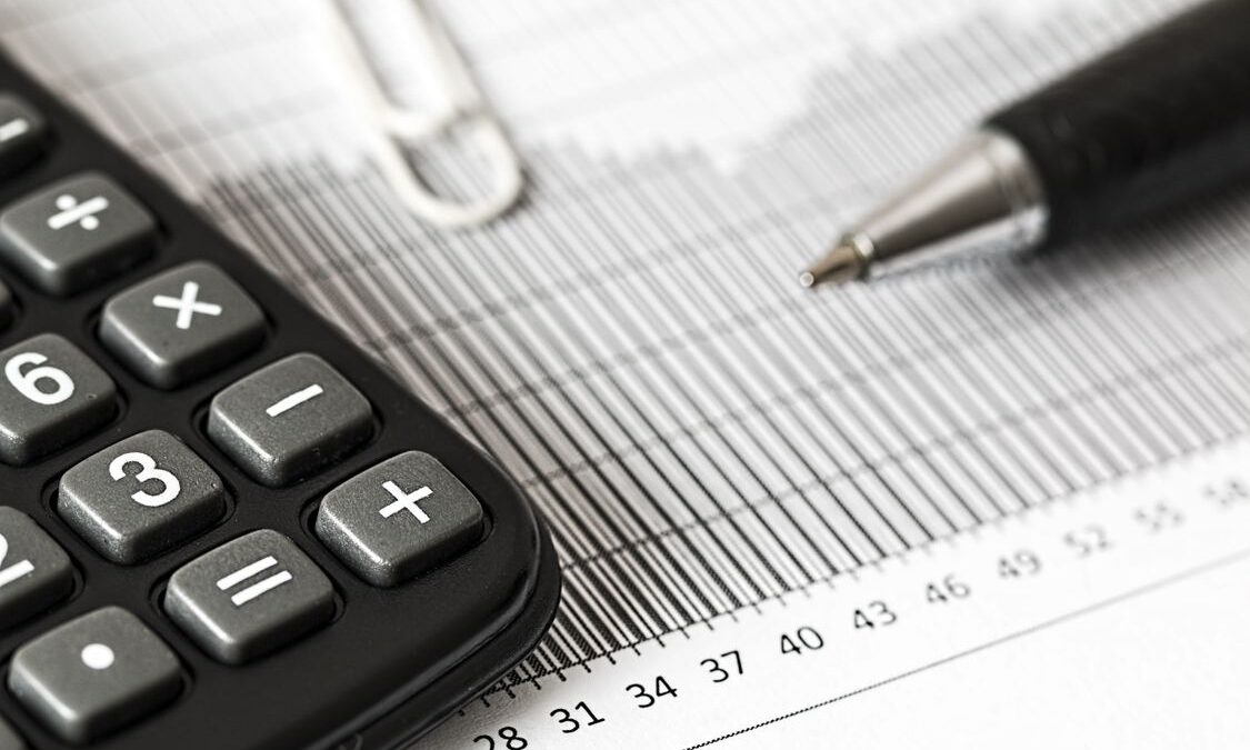 Calculadora y bolígrafo sobre documentos financieros, concepto de impuestos y finanzas