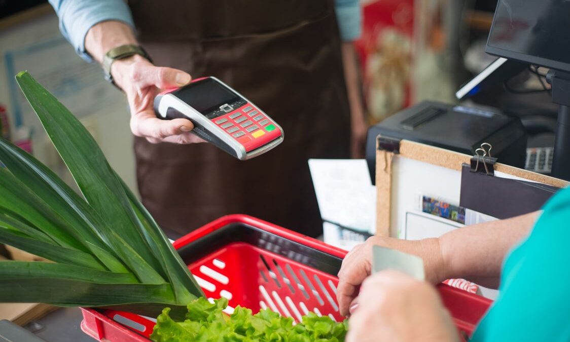 Shopper paying at a grocery store checkout