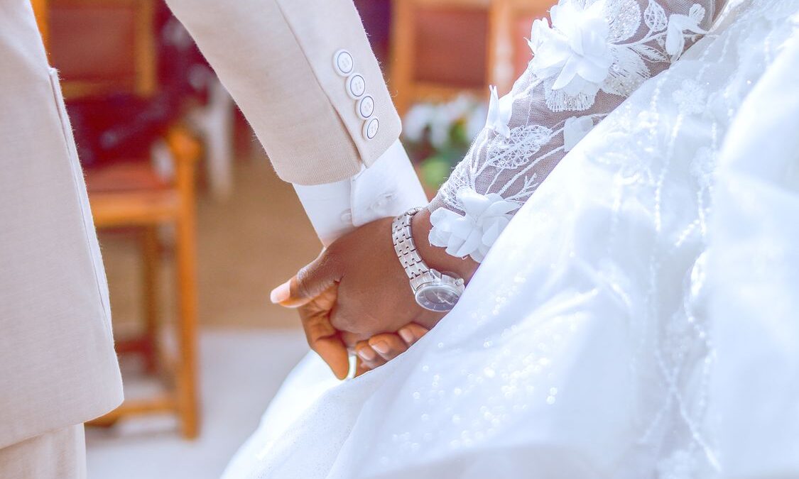 Newlywed couple's hands with wedding rings