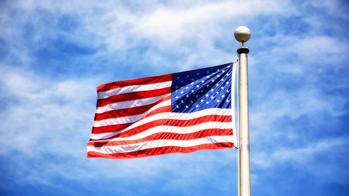 Passport next to the United States flag