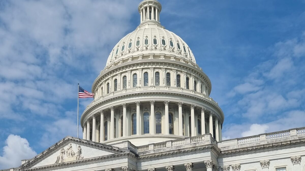 Cúpula del Capitolio de Estados Unidos con bandera y cielo azul