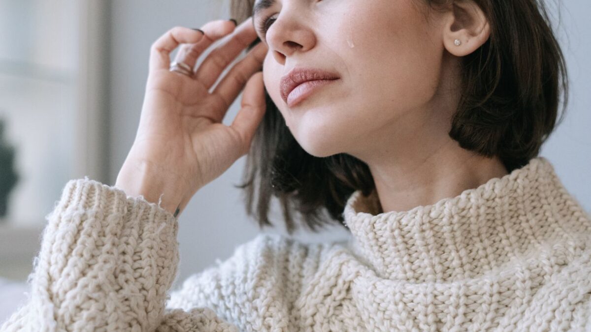 Mujer revisando su teléfono en casa, esperando noticias