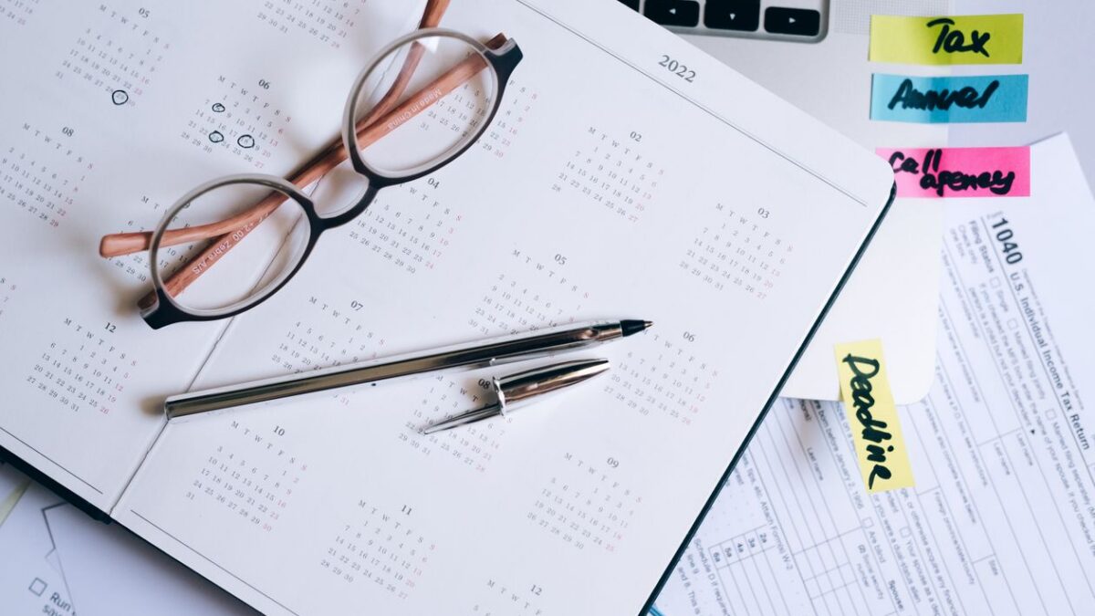 Documentos de taxes, gafas y un bolígrafo sobre un escritorio