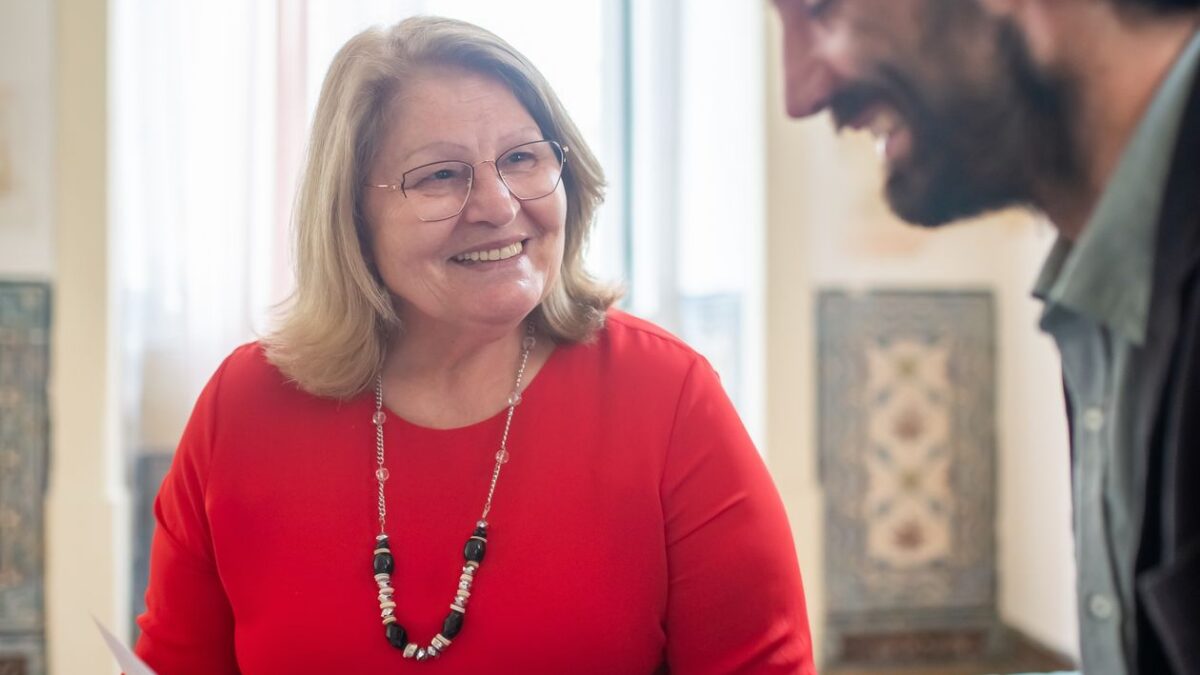 Pareja revisando papeles con su asesor, sonriendo