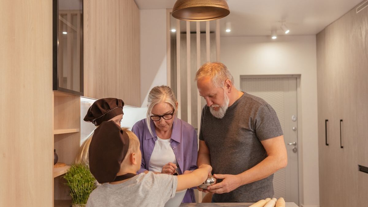 Abuelos cocinando en casa junto a sus nietos