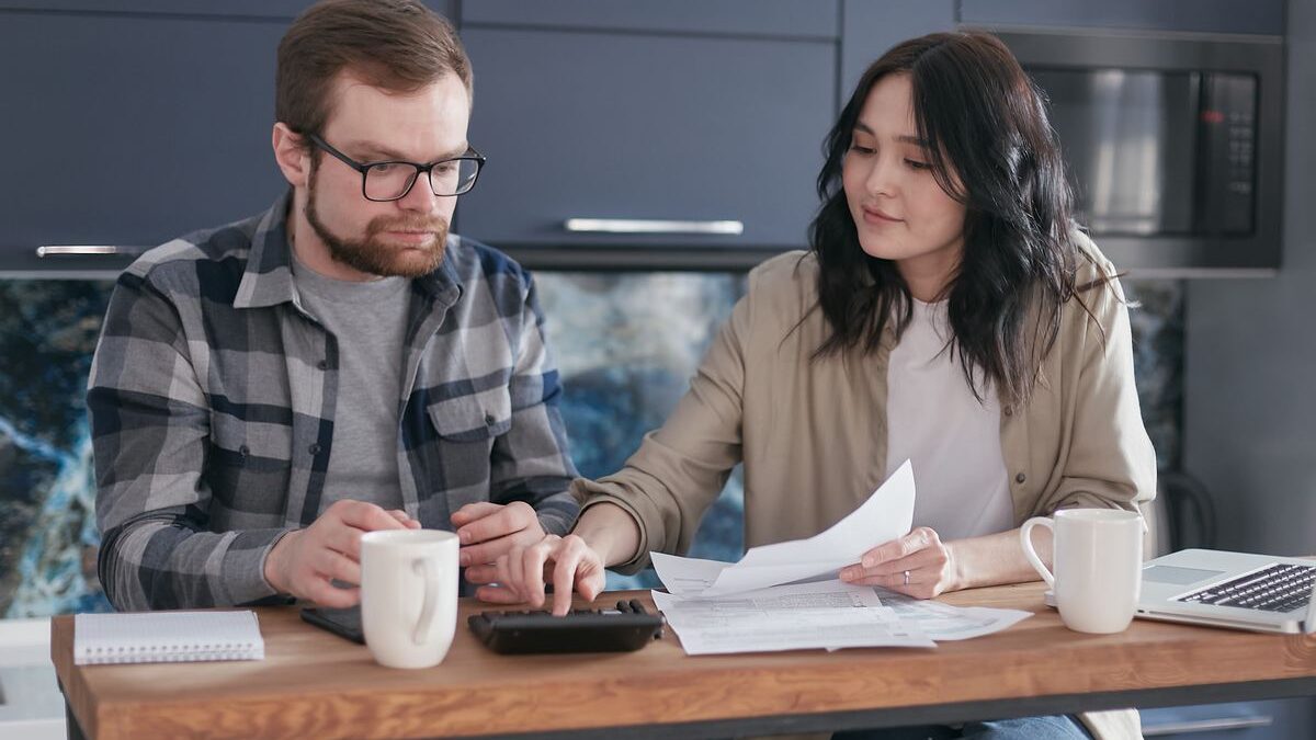 Pareja revisando documentos y finanzas juntos en su casa