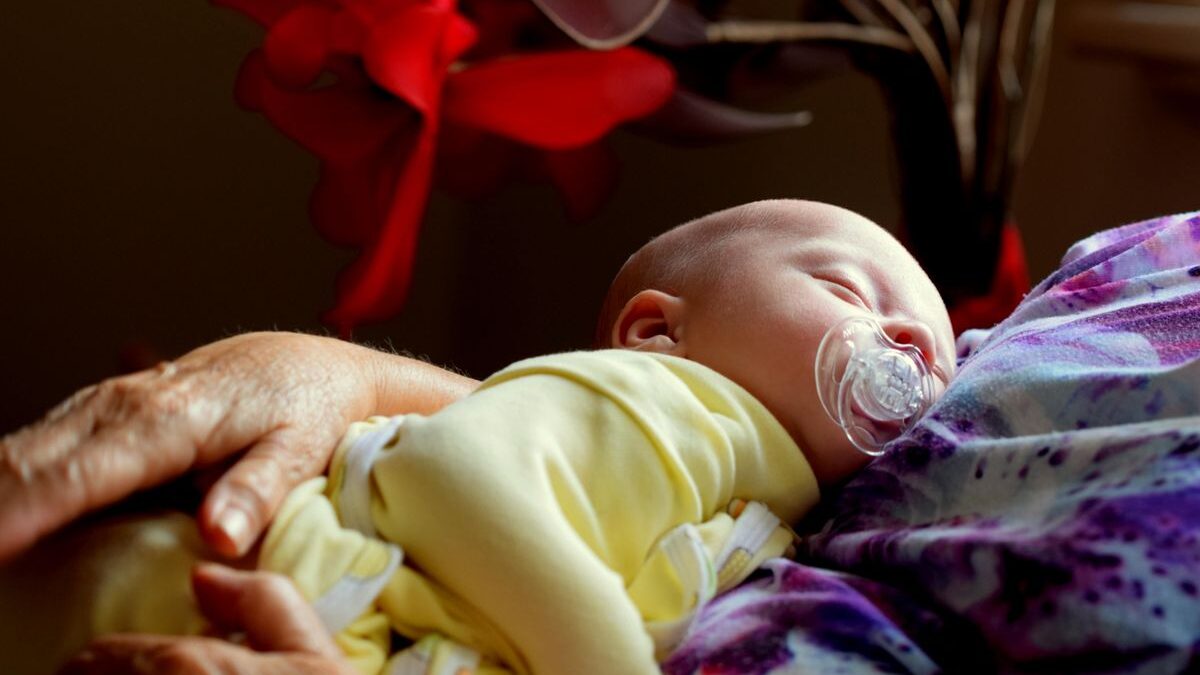Recién nacido dormido en brazos de su madre